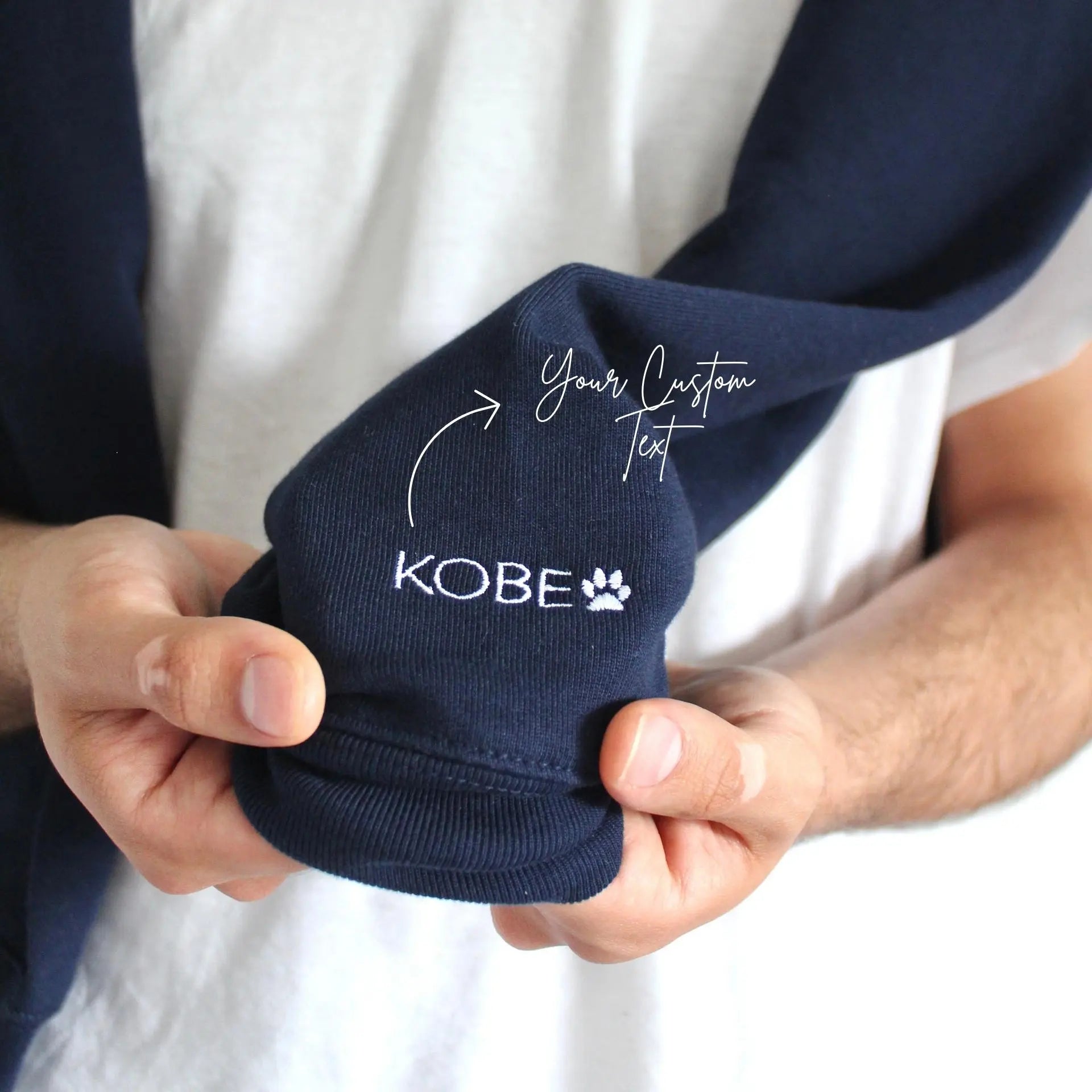Navy blue sock with 'Kobe' branding held by a person against a white background