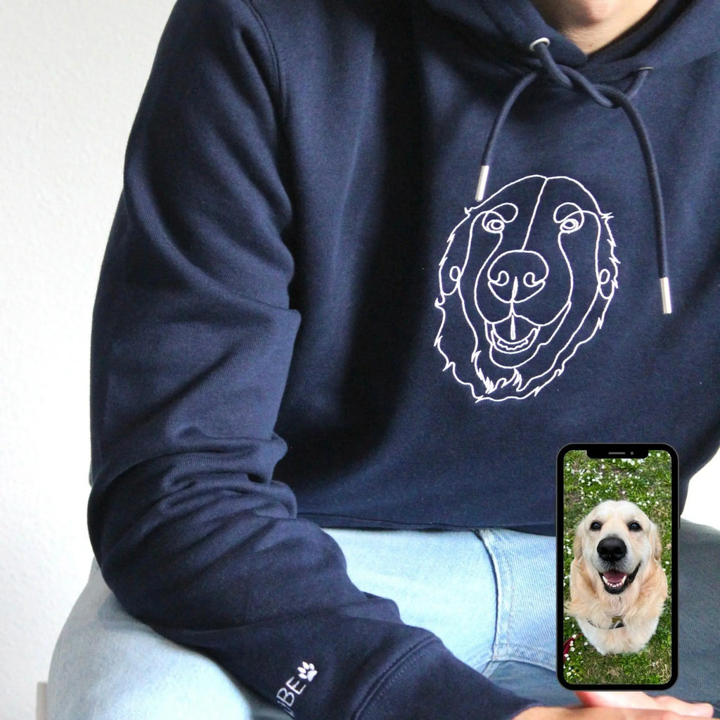 Navy blue hoodie with a white dog illustration and a phone showing a photo of a dog.