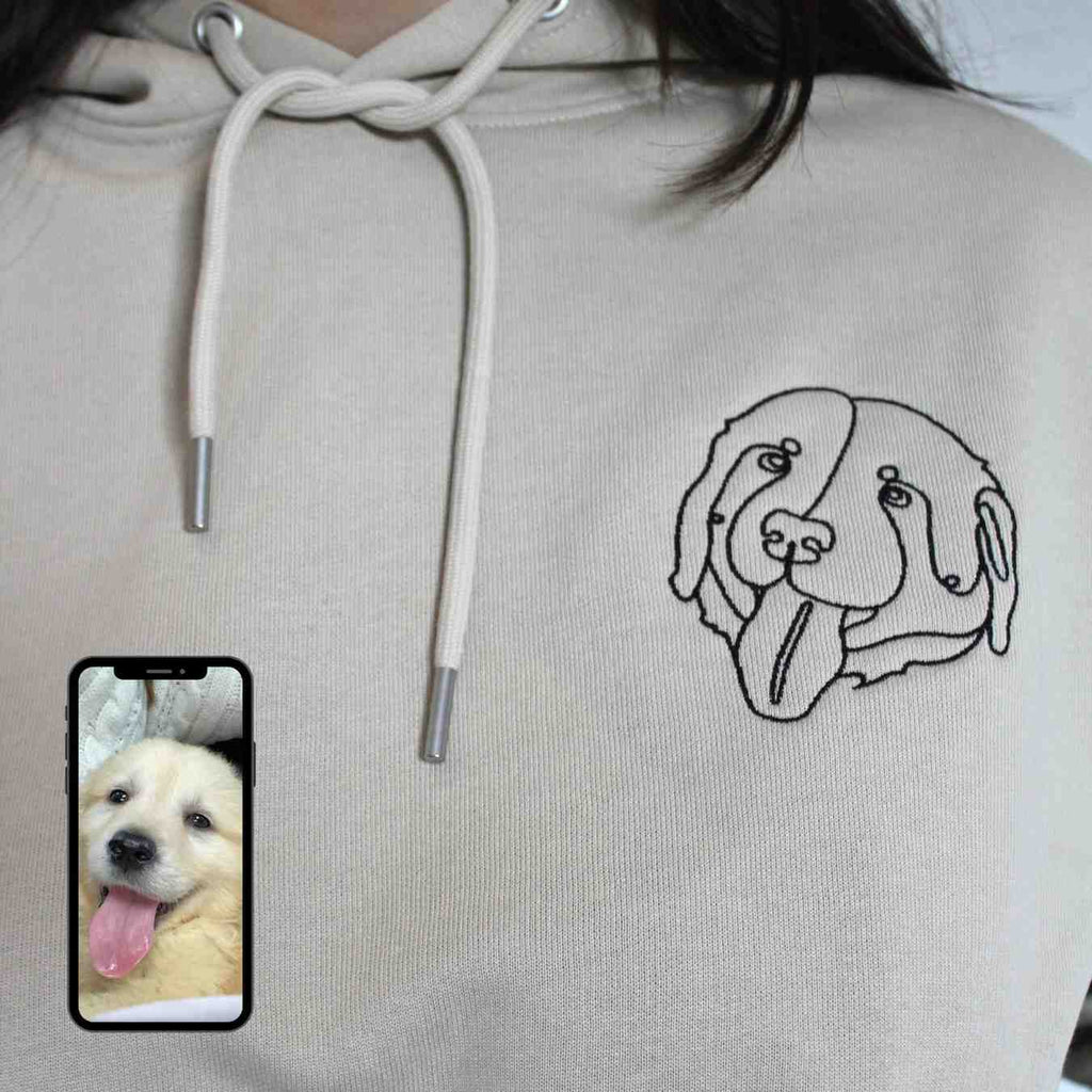 Light gray hoodie with a dog illustration on the chest, next to a smartphone displaying a photo of a puppy.
