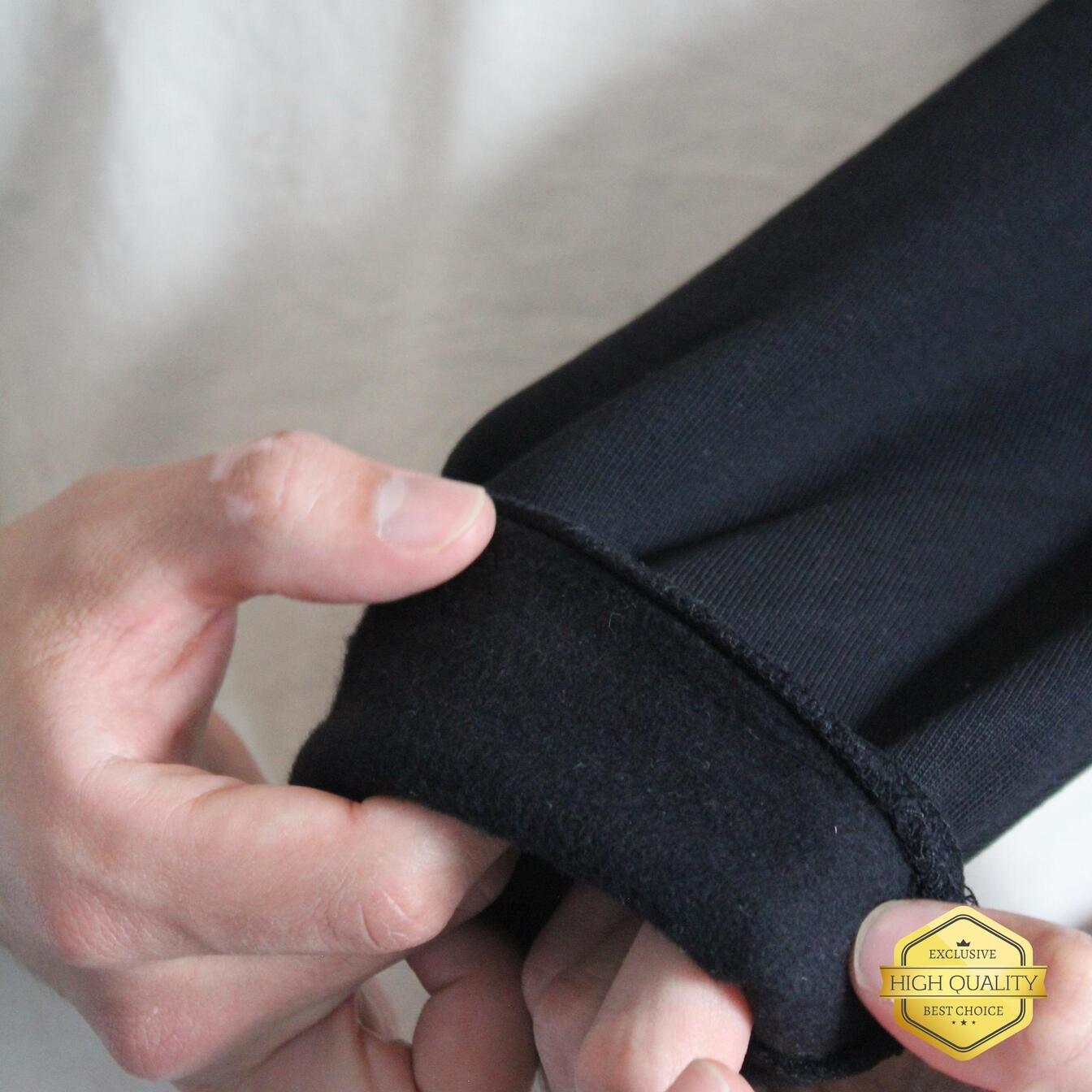 Person holding and inspecting a black fabric with a 'High Quality' badge in the corner.