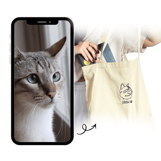 Person holding a phone with a cat on the screen and a tote bag with a cat design.